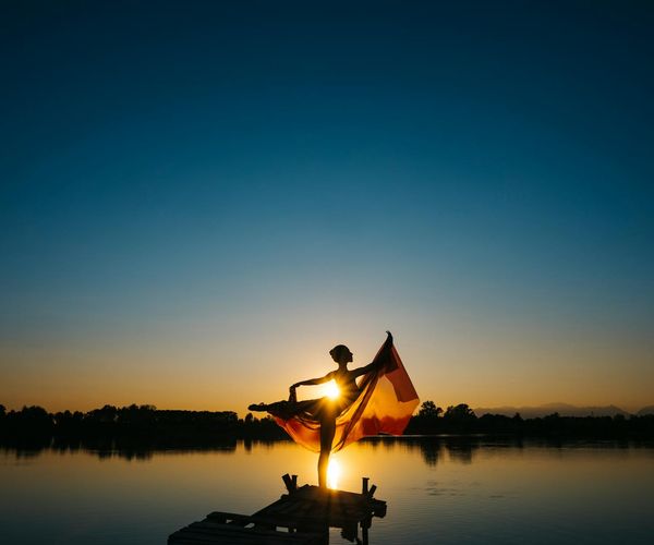 Elegant silhouette of a person in a yoga pose at sunset.